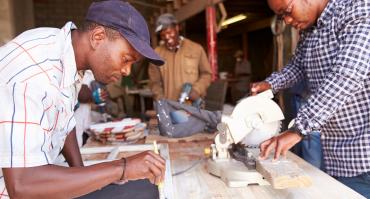 Three men at work in a carpentry workshop South Africa