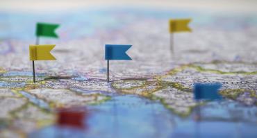Locations marked with pins on world map, global communication network, closeup