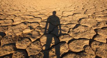 Man standing in desert with shadow behind him