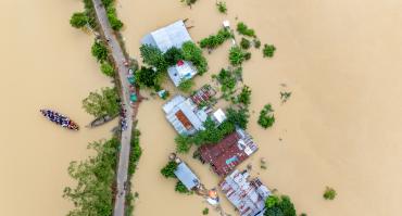 Village flooding in Bangladesh. reflecting this article's theme of climate adaptation.